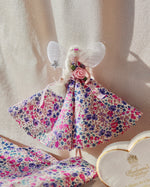 Load image into Gallery viewer, Handmade fairy with pink floral dress and white wings on a textured surface
