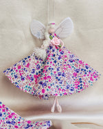 Load image into Gallery viewer, Floral fairy toy with wings on a cream silk

