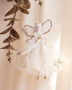 Decorative fairy hanging ornament with gold leaves on a soft beige background