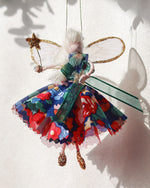 Load image into Gallery viewer, Close-up of Liberty Betsy Fairy&#39;s floral dress and star wand, capturing vintage charm with playful festive details
