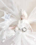 Load image into Gallery viewer, Decorative angel figure with feathers and a star on a soft beige background
