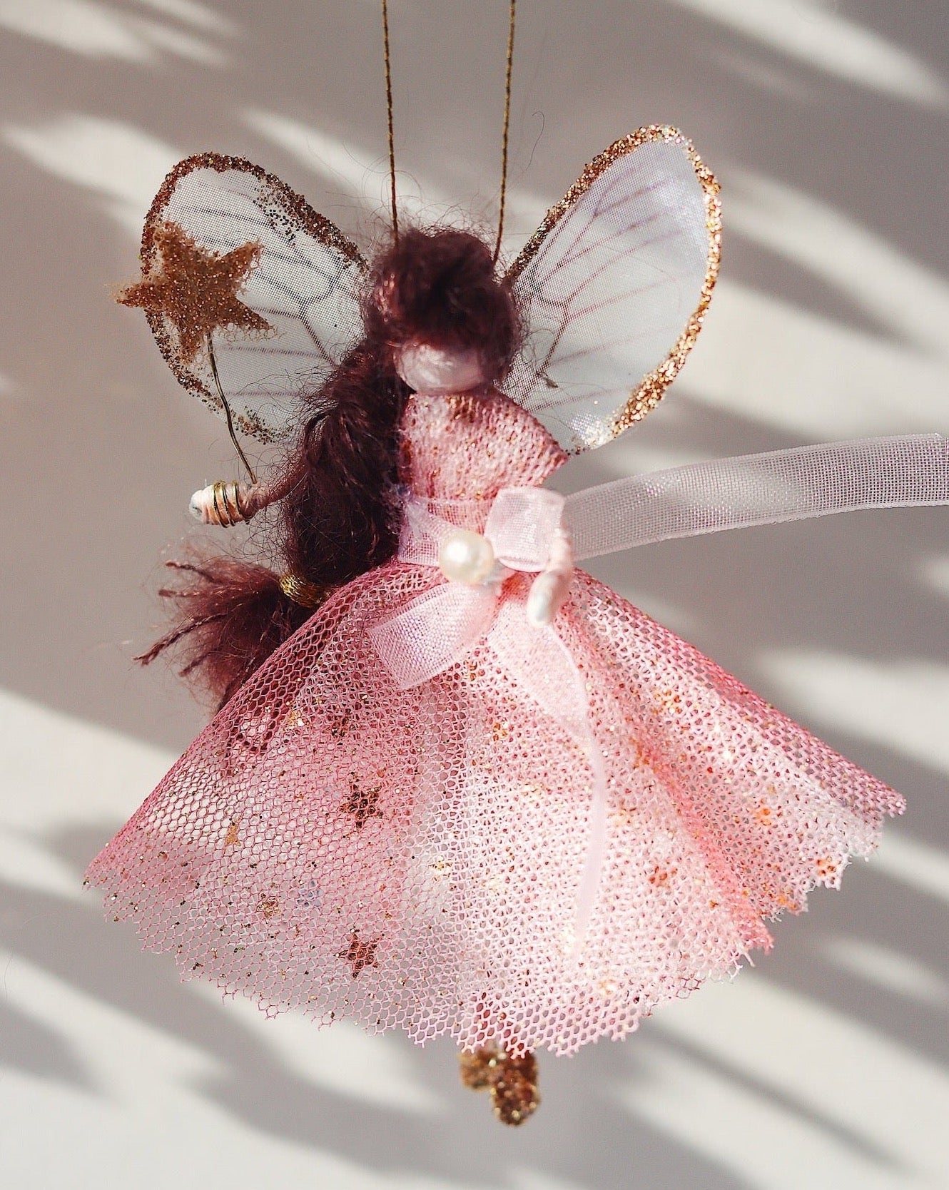 This little fairy is dressed in a pink glitter tulle with a gold star underskirt. She has sashed her gown at the waist with a pink Organza ribbon and a pearl tooth trim. She has little shoes dipped in glitter and her glittered wand to grant you your wishes!]