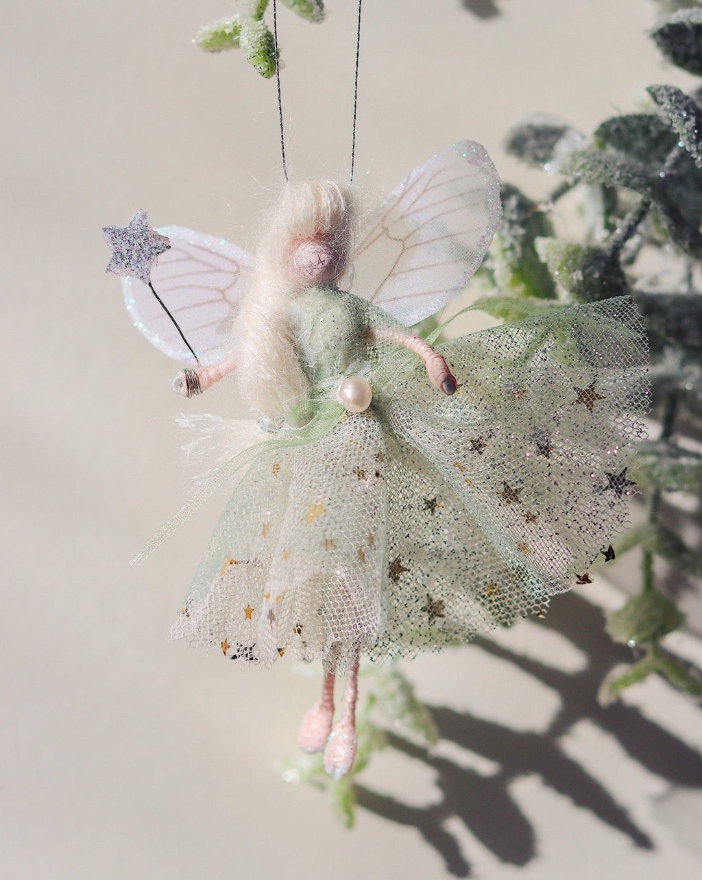 This little fairy is dressed in a pale green glitter tulle with a gold star underskirt. She has sashed her gown at the waist with a green Organza ribbon and a pearl tooth trim. She has little shoes dipped in glitter and her glittered wand to grant you your wishes!