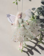 Load image into Gallery viewer, This little fairy is dressed in a pale green glitter tulle with a gold star underskirt. She has sashed her gown at the waist with a green Organza ribbon and a pearl tooth trim. She has little shoes dipped in glitter and her glittered wand to grant you your wishes!

