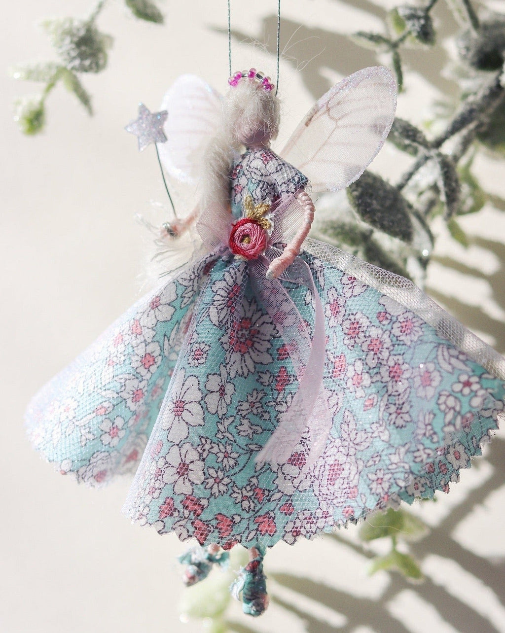 This Fairy is a unique, one-of-a-kind product, handmade by a bridal designer from all her cherished fabrics. It is an item to treasure, a special family heirloom. As each fairy is handmade and unique. This fairy wears a Liberty Print floral dress in blue and pink. The perfect addition to a nursery or gift for a loved one.