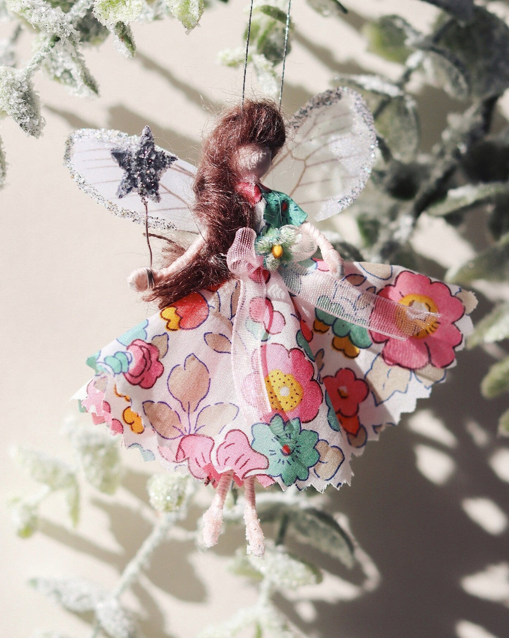 This little fairy is dressed in a Liberty print fabric. She has sashed her gown at the waist with a ivory Organza ribbon and a little rose trim. Her little shoes are dipped in glitter. She has delicate wings made from silk Organza and of course, her glittered wand that brings you magic!