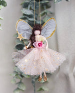 Load image into Gallery viewer, A decorative fairy ornament hanging from a tree branch, featuring translucent gray wings with gold glitter trim, a pink and white tulle dress with gold star details, and a pink flower at the waist.
