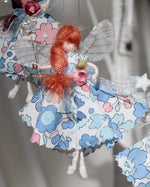 Load image into Gallery viewer, This little fairy is dressed in the “Betsy” Liberty print fabric. She has sashed her gown at the waist with a pale pink Organza ribbon and a little rose trim. Her little shoes are dipped in glitter. Her delicate wings are made from silk Organza and of course, her glittered wand
